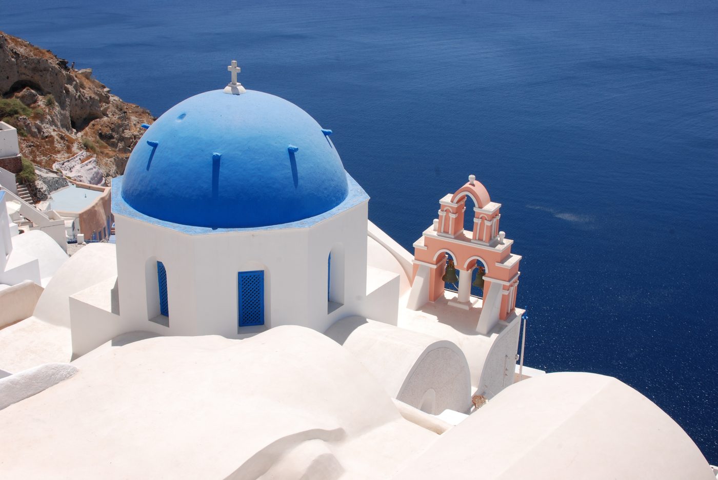 Blue-domed church with white walls overlooking the Aegean Sea in Oia, Santorini