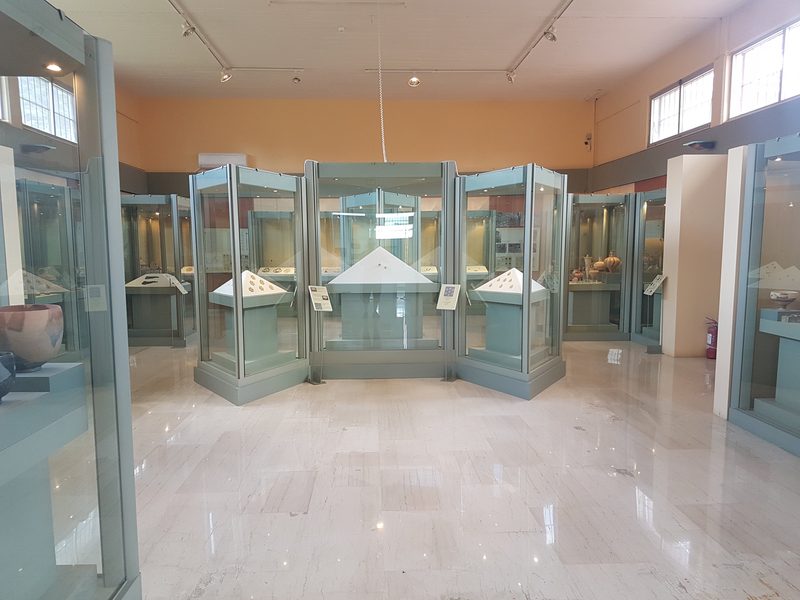 Display cases of ancient pottery and artefacts inside the Archaeological Museum of Nemea