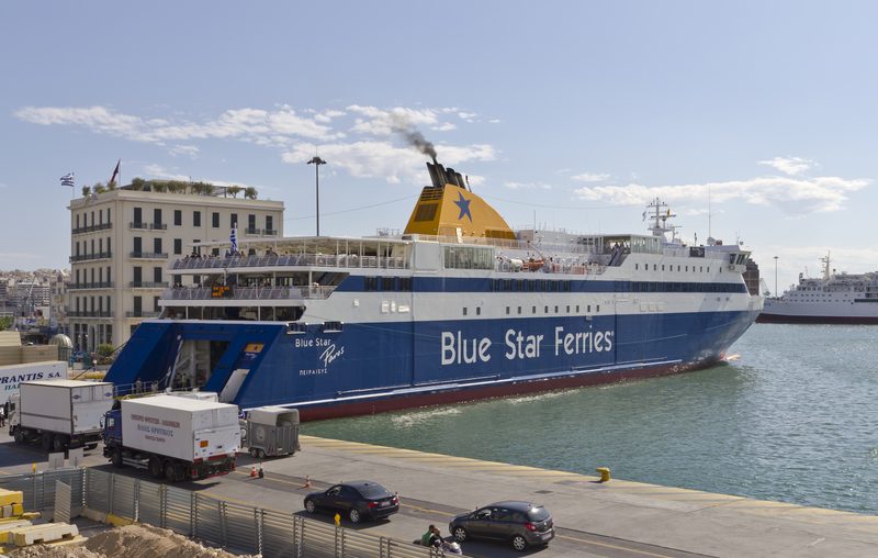 Ferry docked at Piraeus port in Greece with the harbour and buildings visible