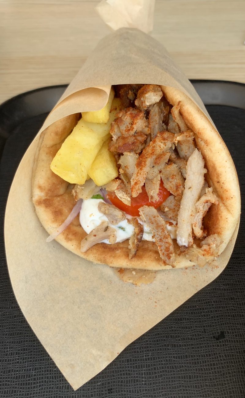 Close-up of a Greek gyros pita wrap with meat, vegetables and sauce