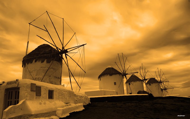 Iconic windmills of Mykonos positioned on a hillside overlooking the harbour