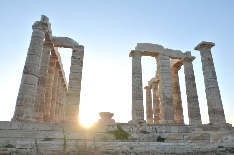 Temple of Poseidon Doric columns silhouetted against a golden sunset at Cape Sounion Greece