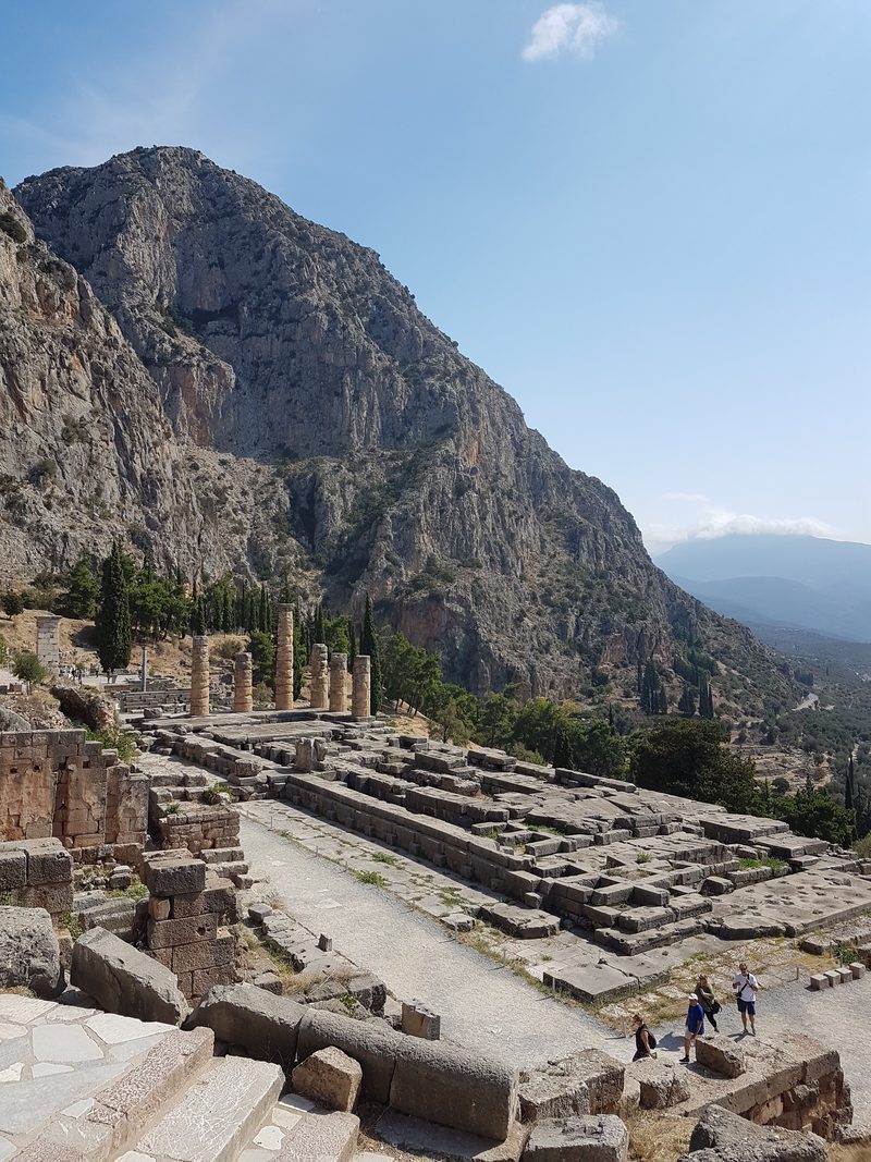 The ancient theatre and sanctuary terraces at Delphi seen from above, with the Phaedriades cliffs rising behind