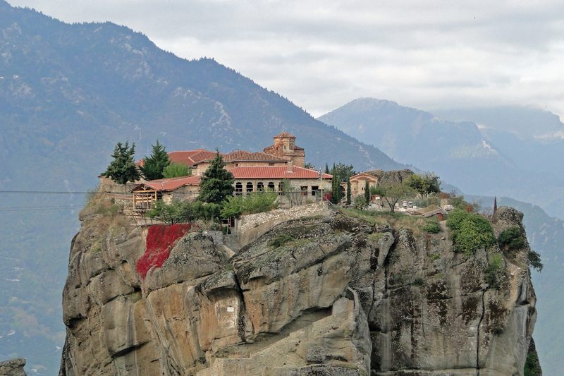 Monastery of the Holy Trinity in Meteora perched on top of a sheer sandstone pillar, with stone steps carved into the rock face leading up to it