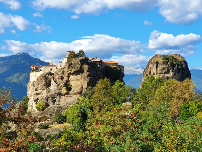 One of the Meteora monasteries crowning a rock pillar, with the Pindus mountains rising behind