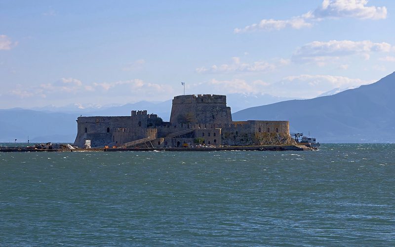 Bourtzi castle sitting on a small island in the harbour of Nafplio, with the sea and mountains in the background