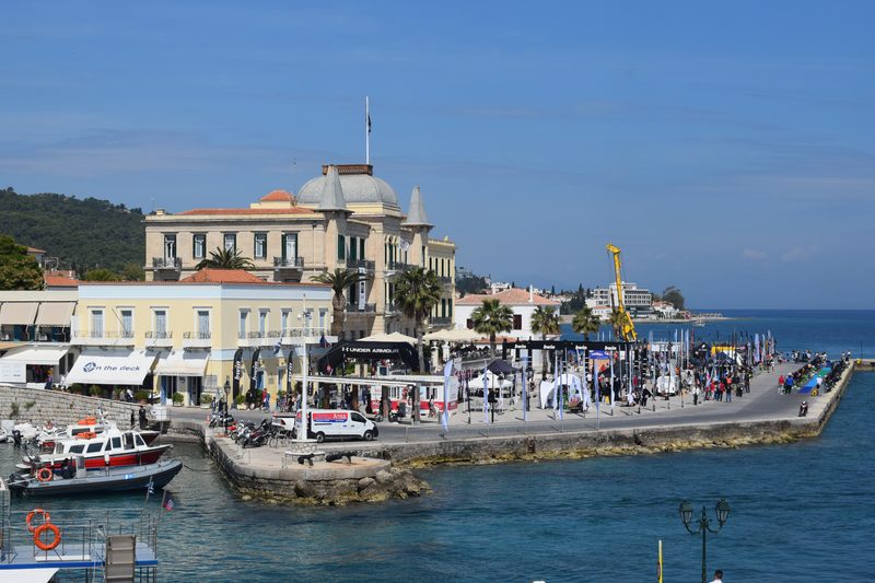 Spetses island viewed from the sea, with the harbour waterfront, neoclassical buildings, and the Anargyrios and Korgialenios School on the hill above town