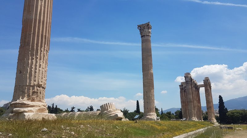 Towering Corinthian columns of the Temple of Olympian Zeus, one of the tallest ancient temples in Greece, against a clear blue sky