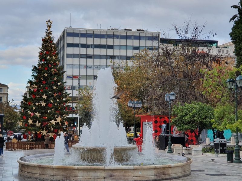 Bundled-up visitors near Syntagma Square's Christmas tree on a grey winter day